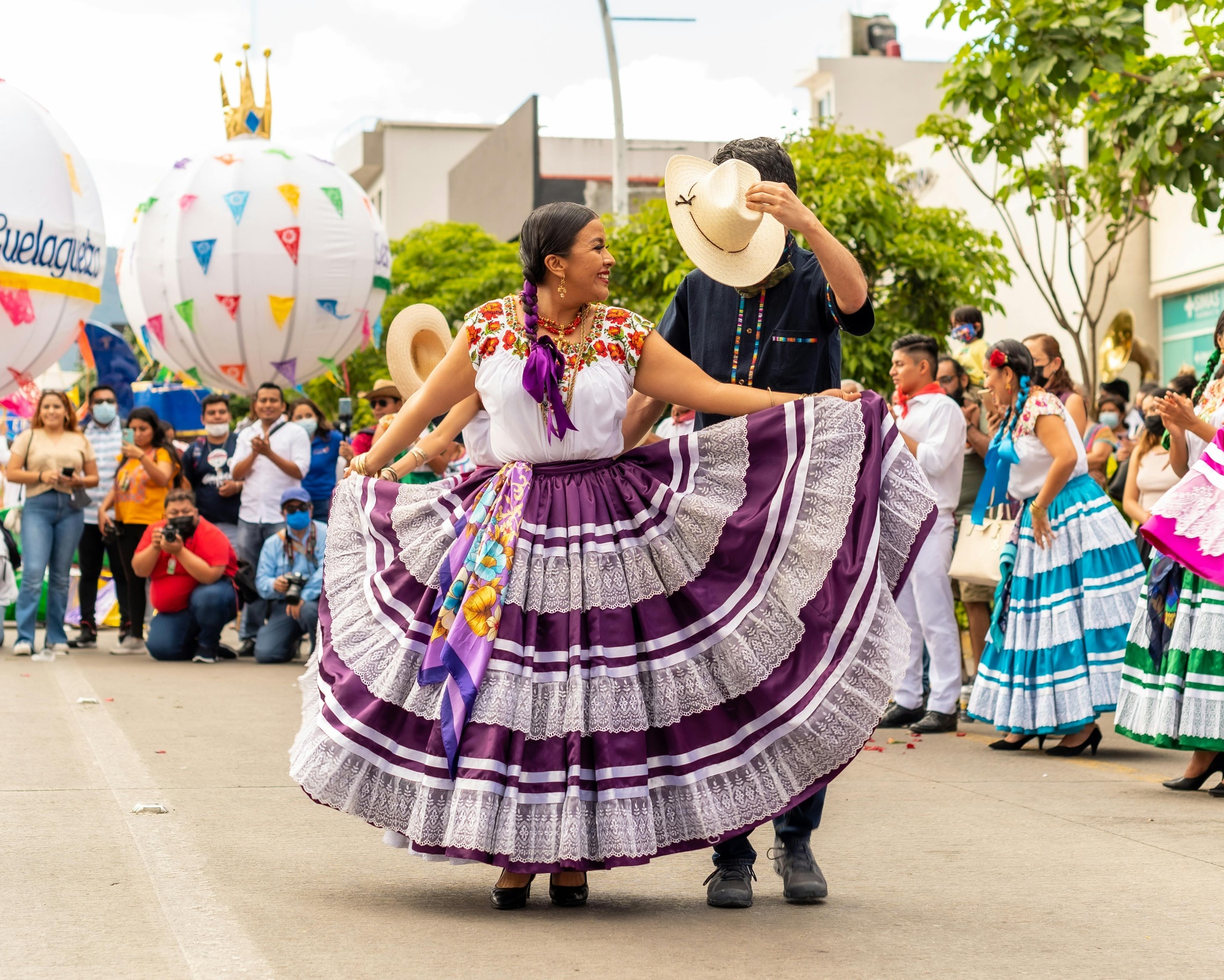 Bailarines mexicanos tradicionales actuando con vestidos coloridos en un festival cultural en Oaxaca